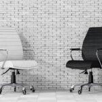 Bürostühle aus schwarzem und weißem Leder vor einer Ziegelwand.