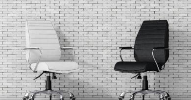Bürostühle aus schwarzem und weißem Leder vor einer Ziegelwand.