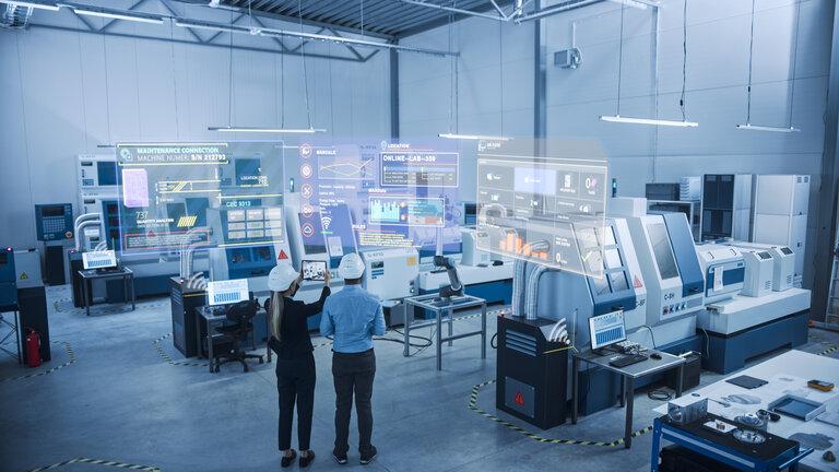 Industrie 4.0 Fabrik: Zwei Ingenieure nutzen digitale Tablet-Computer mit Augmented-Reality-Software, um sich mit High-Tech-Maschinen und Roboterarmen zu verbinden und die Wartung und Diagnose von Anlagen zu visualisieren